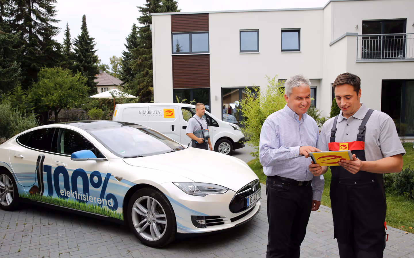 E-Mobilität - Mitarbeiter mit Kunden vor Elektrofahrzeugen 100% elektrisch &middot; Elektro-Adam-Mühlheim