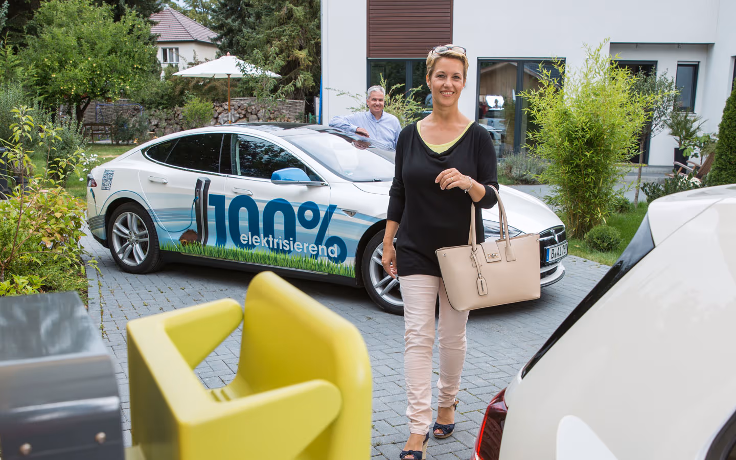 E-Mobilität - Kundin vor Elektrofahrzeugen 100% elektrisierend &middot; Elektro-Adam-Mühlheim